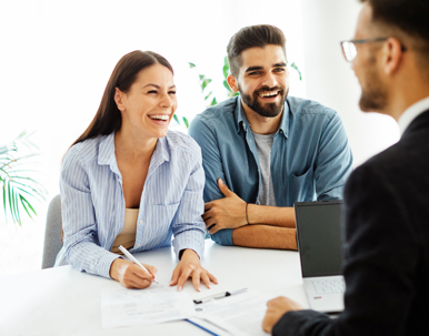 happy couple signing documents with a lawyer